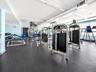Fitness area featuring rubber flooring, recessed lighting, and blue accent walls