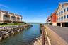Waterfront properties with direct water access, private balconies, and a brick paver walkway