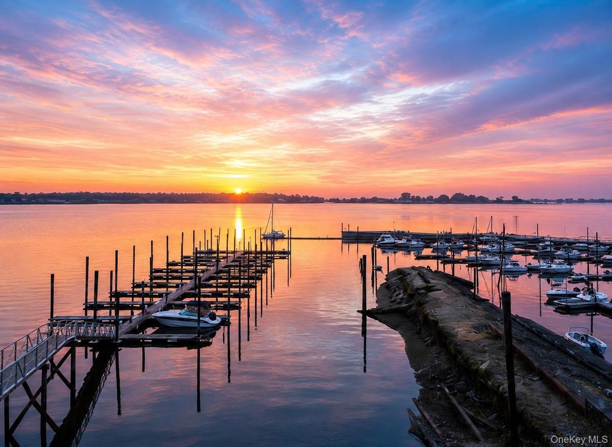 Waterfront setting featuring a marina with multiple boat slips and a lengthy dock structure