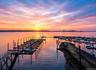 Waterfront setting featuring a marina with multiple boat slips and a lengthy dock structure