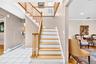 Hardwood staircase with natural wood balusters, white risers, and a curved bottom step