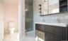 Full bath with light tile patterned floors, a shower stall, double vanity, and tasteful backsplash