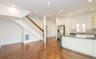 Kitchen with open floor plan, white cabinetry, stainless steel refrigerator with ice dispenser, dark countertops, and backsplash