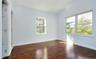 Unfurnished bedroom with dark wood-type flooring and vaulted ceiling