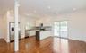 Kitchen featuring stainless steel appliances, dark countertops, white cabinets, open floor plan, and tasteful backsplash