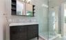 Full bathroom with tile walls, double vanity, a stall shower, decorative backsplash, and light tile patterned floors
