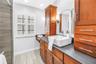 Primary Suite Vanity with dual storage units for bath products.  Modern Sink, Granite Counters