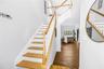 Open Feel for Stairs with light colored natural wood and soaring ceilings to the upstairs loft and office space
