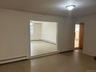 Recessed wall opening into family room, neutral wall paint, ceiling-mounted light fixture, and baseboard heating