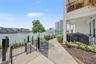 Gated entry to a paved waterfront walkway, perfect for a scenic stroll along the water.