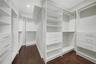 Spacious primary suite closet featuring professional custom built-in cabinetry and shelving.Spacious master closet featuring custom built-in cabinetry