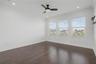 hird-level primary bedroom featuring a trio of west-facing windows that fill the space with natural light.