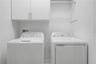 Third-level laundry room featuring high-efficiency washer and dryer connections with ample storage space.