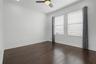Third-level secondary bedroom offering a bright, comfortable space with abundant natural light from east-facing windows.