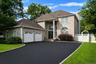 Exterior with brick facade, 2-car garage and wide driveway.