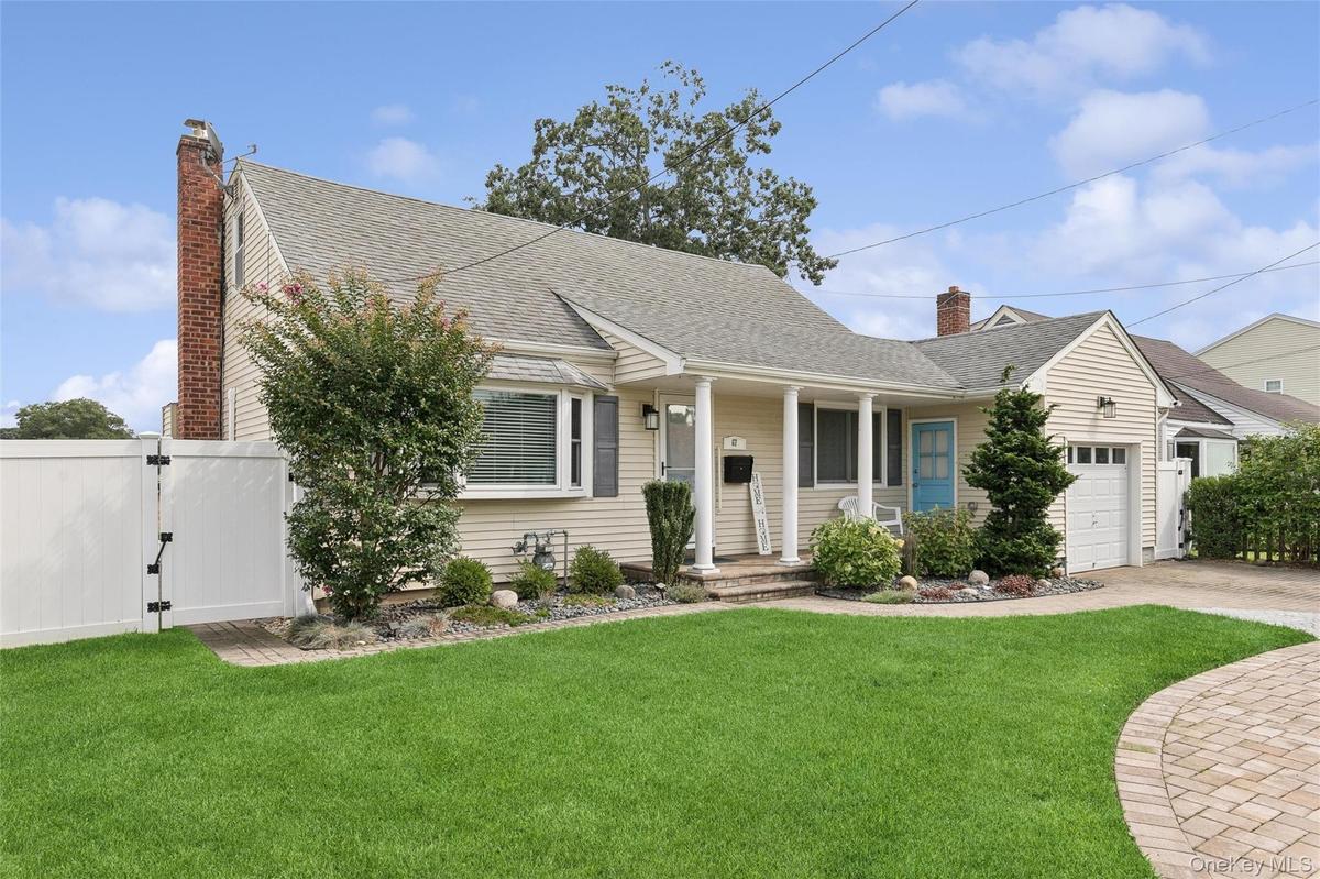 Siding exterior with a covered porch, bay window, and attached garage