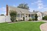 Siding exterior with a covered porch, bay window, and attached garage