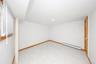 White tile flooring, wood trim, flush-mount ceiling lighting, and a wood-paneled door