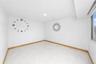 Recessed ceiling lighting, light-toned tile flooring, light wood-finish baseboards, and a window with a white frame