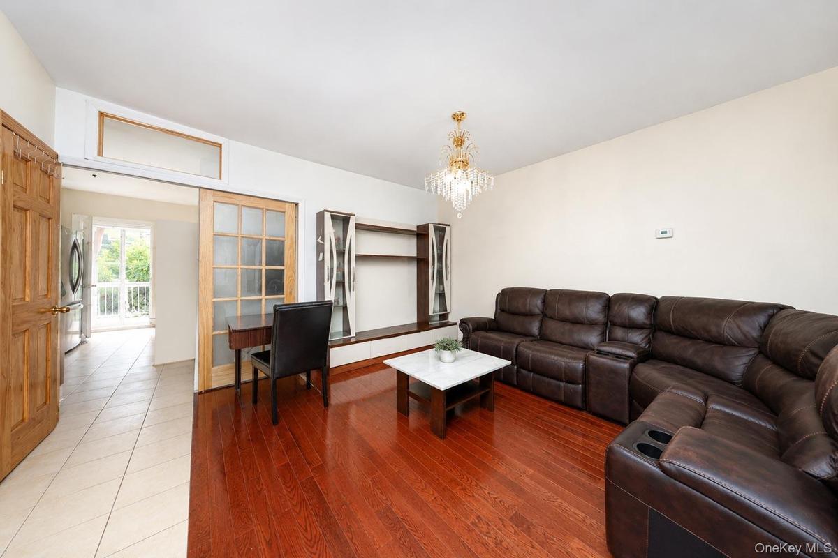 Hardwood flooring, crystal chandelier, built-in shelving, French doors with frosted glass, and transom window