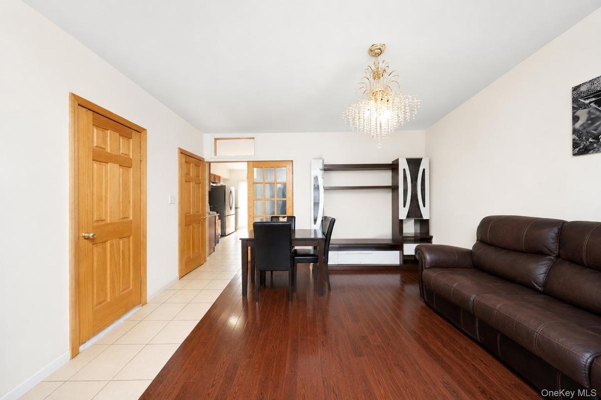 Hardwood flooring, recessed ceiling light fixture, crystal chandelier, wood panel doors, tile flooring