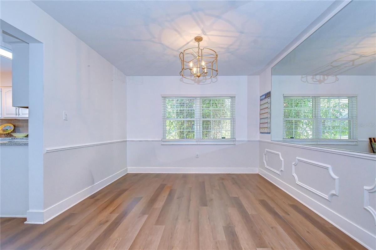 Formal dining room with classic wall trim and modern chandelier.