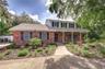 Front exterior view showing covered porch and manicured front lawn.