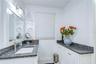Beautifully remodeled bath features dual vanities and a walk-in shower