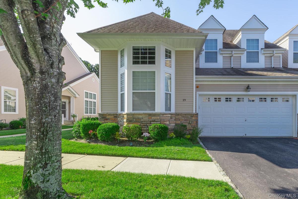 Exterior Street view featuring bay windows, stone facade accents,  and a newly paved driveway