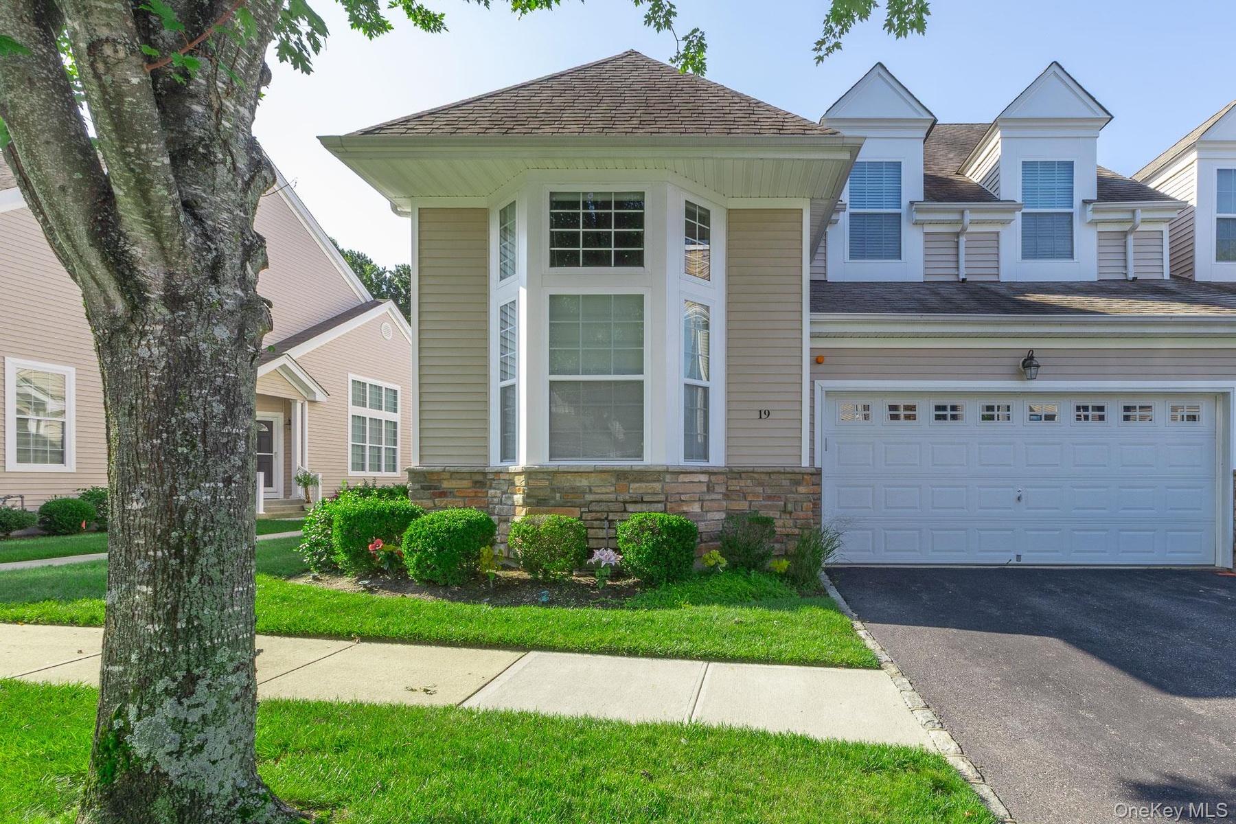Exterior Street view featuring bay windows, stone facade accents,  and a newly paved driveway