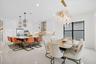 Open-concept living space featuring a modern kitchen with a large central island, white glossy cabinetry, and stainless steel appliances