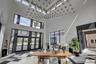 Grand foyer featuring a high ceiling with a multi-tiered spherical chandelier, checkerboard tile flooring, and a full-light glass entry system