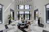 Grand entry foyer featuring a striking geometric-patterned tile floor, soaring ceilings, expansive windows, and a multi-level chandelier