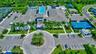 Aerial view showcasing a comprehensive community amenity center with multiple pools, tennis courts, and a basketball court