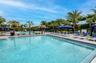Expansive aquatic amenity featuring multiple swimming pools with integrated steps, surrounded by a paver deck