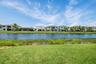 Expansive green lawn bordering a natural waterway with lush vegetation