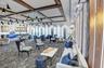 Spacious common area featuring textured carpeting and a coffered ceiling with numerous pendant lights