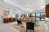 Open-concept living space featuring a spacious kitchen island, high-gloss cabinetry, and large format tile flooring