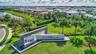 Community entrance featuring a modern water feature and lush tropical landscaping