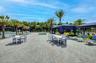 Expansive paver patio with multiple seating areas and palm trees