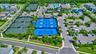 Expansive recreational complex featuring multiple tennis courts, pickleball courts, and a large parking area