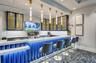 Custom bar area featuring under-counter lighting, a multi-tiered countertop, and a built-in television