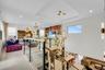 Open-concept upper-level living space featuring a glass railing, wood-finish flooring, a recessed ceiling, geometric pendant lighting, and multiple wi