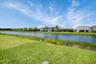 Lush green lawn bordering a tranquil pond with natural vegetation