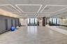 Spacious multi-purpose room featuring wood-finish flooring and a full wall of mirrors