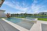 Private patio featuring a swimming pool, integrated spa with stone-finish surround, and a fenced perimeter backing onto a pond