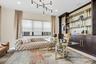 Dedicated office space featuring built-in shelving, dark wood-finish cabinetry, a large window, recessed lighting, and a modern chandelier