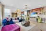 Spacious entertainment area featuring wood-finish flooring, recessed lighting, and a modern chandelier