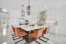 Spacious kitchen featuring an oversized island with countertop seating, high-gloss white cabinetry, and stainless steel appliances