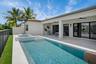 Modern rectangular swimming pool with integrated spa, surrounded by a paved patio